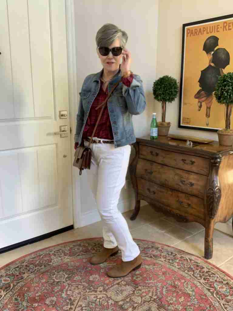 A light denim jacket in winter worn over a plaid shirt, with white denim jeans.  I added a brown cross-body bag, brown booties, and black Oakley sunglasses.