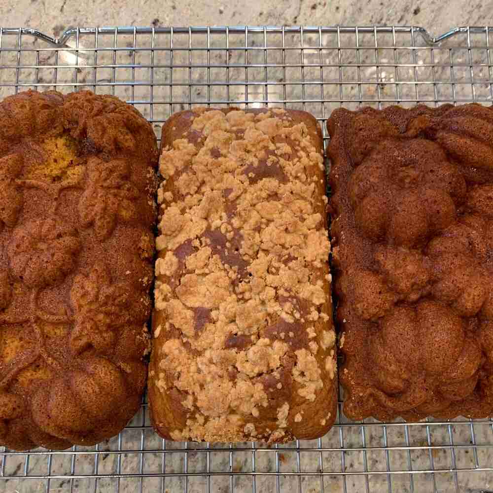 Delicious Pumpkin Bread with Streusel Topping.  here we have three loaves displayed on a wire baking rack.