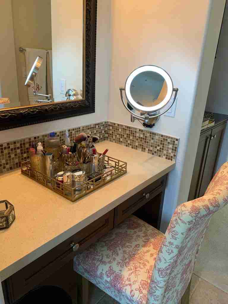 Here is my makeup magnifying mirror while it is lit up,  It is sleek and polished nickel in the finish.  It has two levels of magnification.  In addition you can see my almost completed makeup tray with all my products displayed in votive holders.