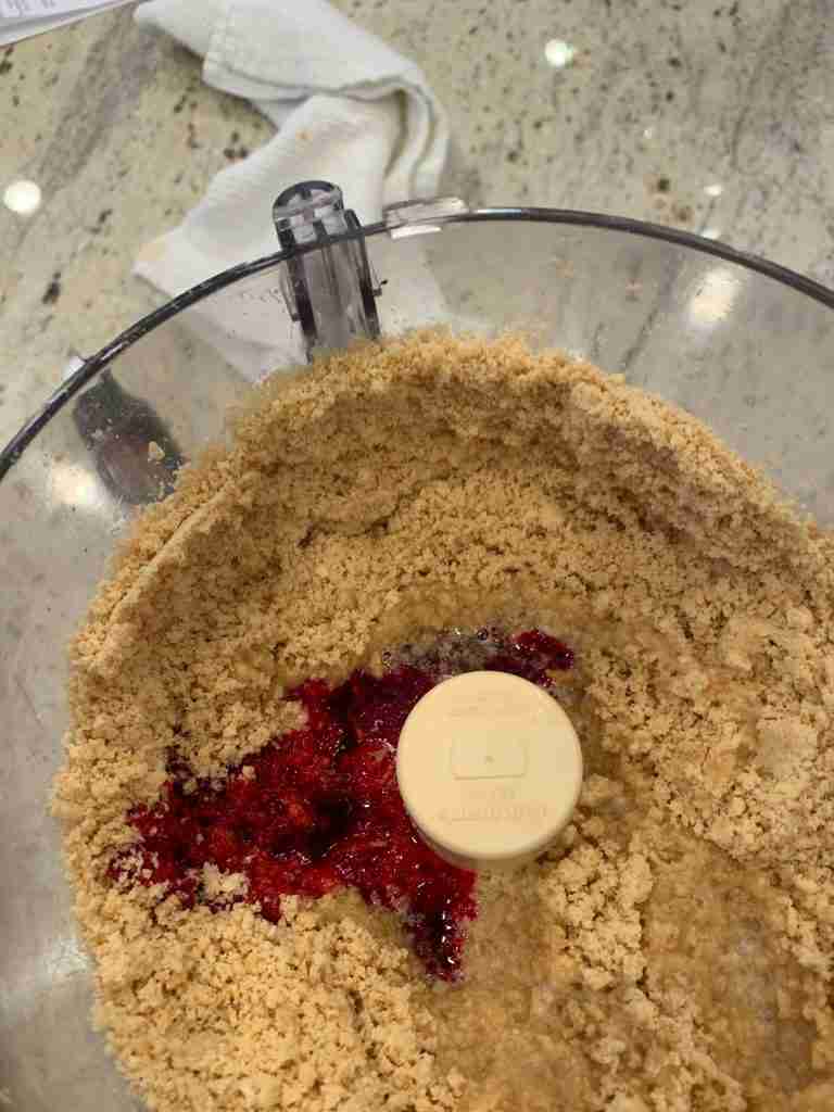 Cookie crumbs with red food dye added to the processor.