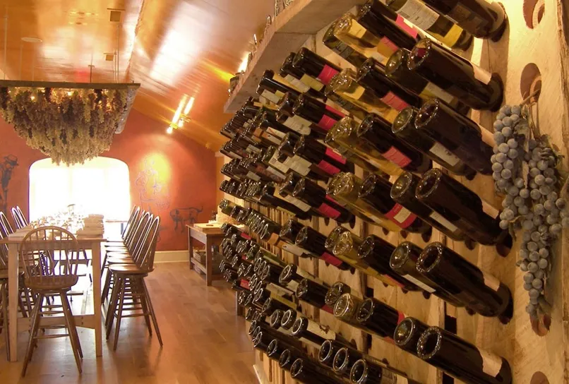 Interesting wine rack with bottles bottles displayed on an angle as well as decorative grapes.