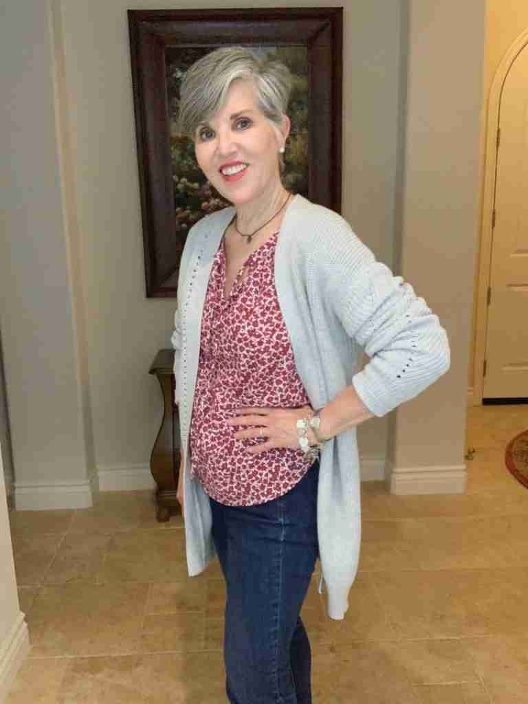 burgundy boho top with an oversized gray cardigan worn over skinny jeans.  Leopard slip-on shoes, pearl earrings, and amber necklace and a silver charm bracelet.