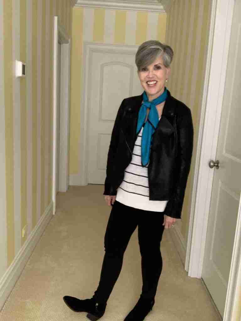 first photo of a black moto jacket worn over a long black and white striped sweater.  my pants are black pointe leggings and I added black suede booties.  For a dash of color, I wore a vintage teal blue with tiny black dots scarf around my neck.