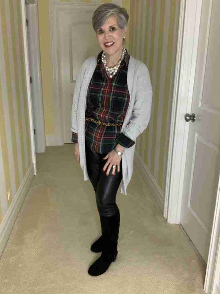 Soft gray cardigan over a plaid shirt with a chunky pearl choker and leopard belt. The pants are vegan black leather and pointer leggings with suede boots.