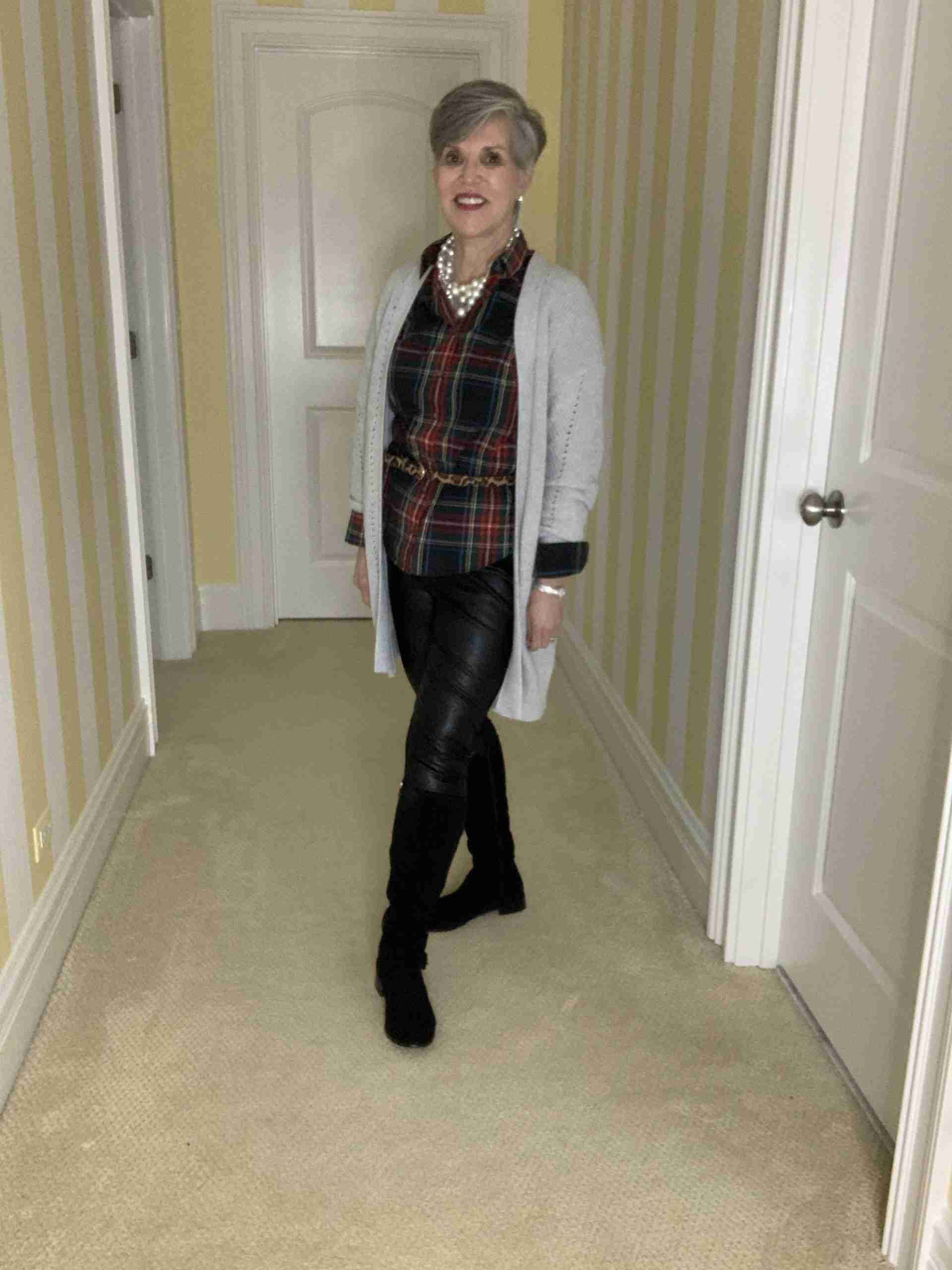 First of three plaid shirt outfits: Soft gray cardigan over a plaid shirt with a chunky pearl choker and leopard belt. The pants are vegan black leather and pointer leggings with suede boots.