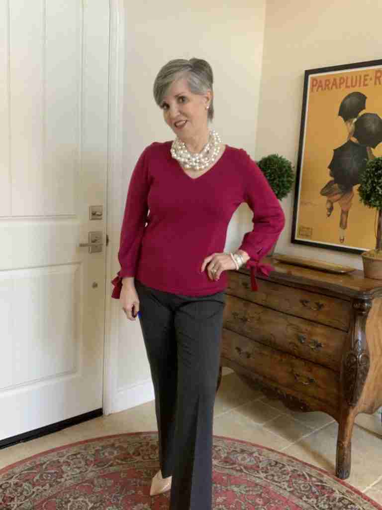 Happy Valentine's Day outfits can consist of this fuchsia sweater, gray trousers, and a pearl choker. 