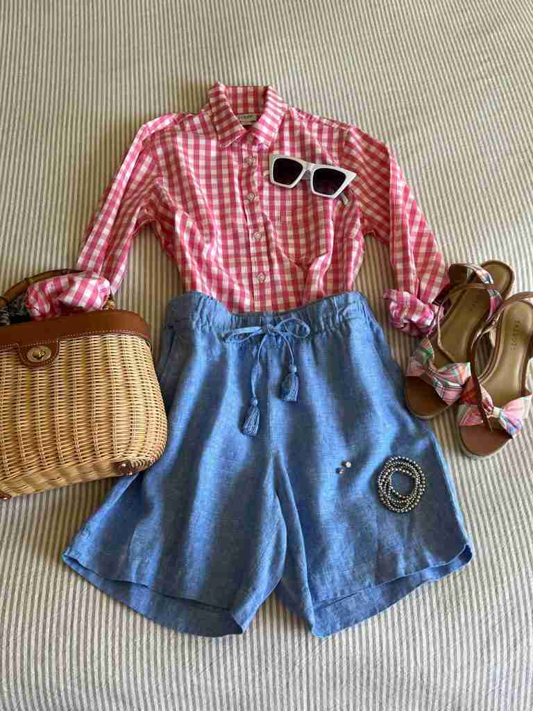 A pink gingham shirt with blue draw-string shorts, a wicker bag and espadrilles.