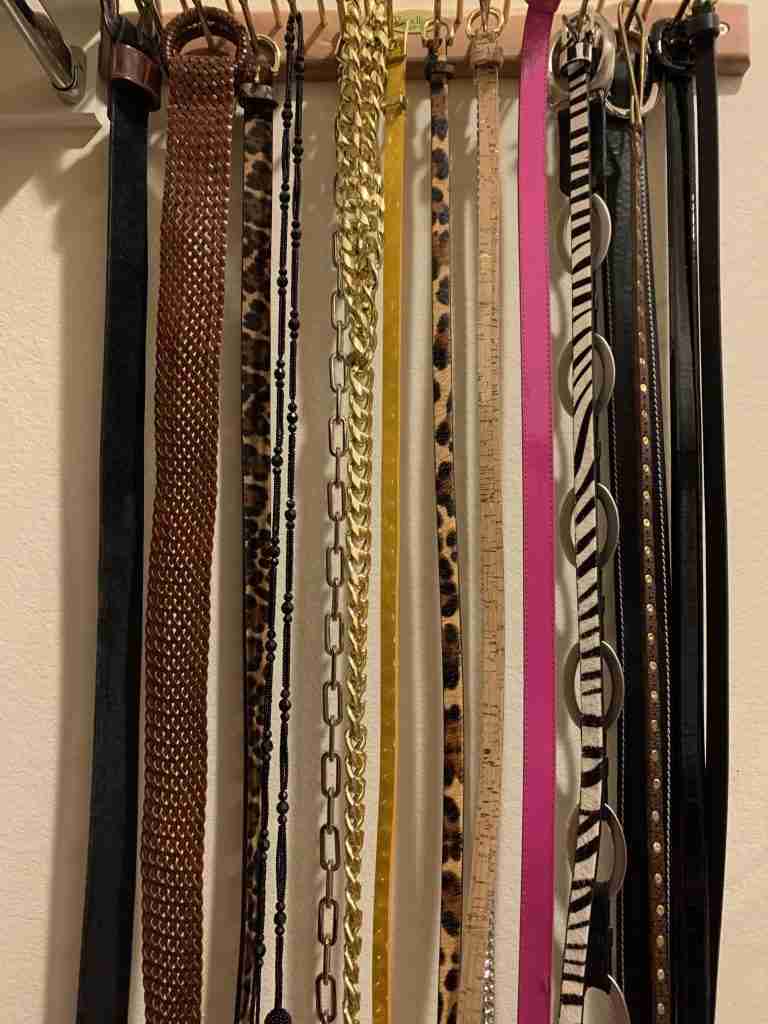 Belts are organized on a tie rack.