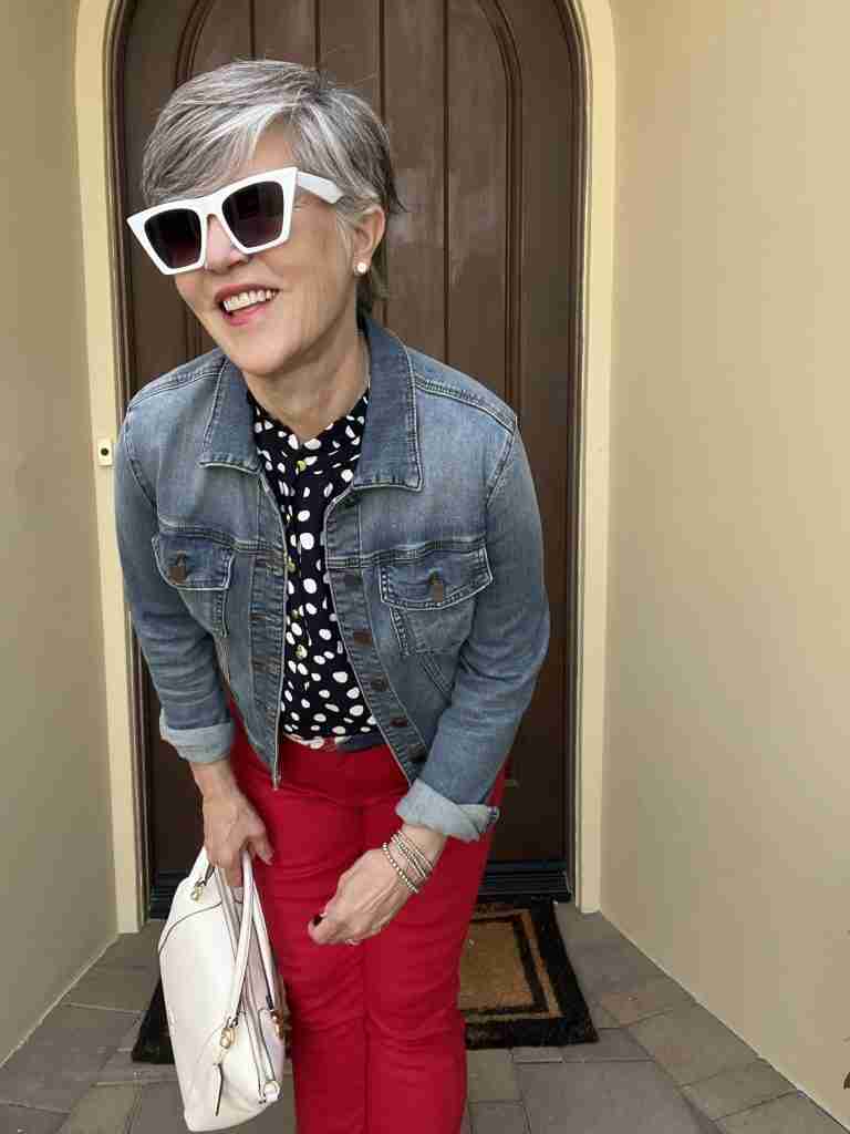 I love this first outfit!  I paired a really dark navy polka dot sleeveless top with a medium-wash jean jacket and some bright red jeggings.  I am accessorized with "diamond" stud earrings and white cat-eye sunglasses.  