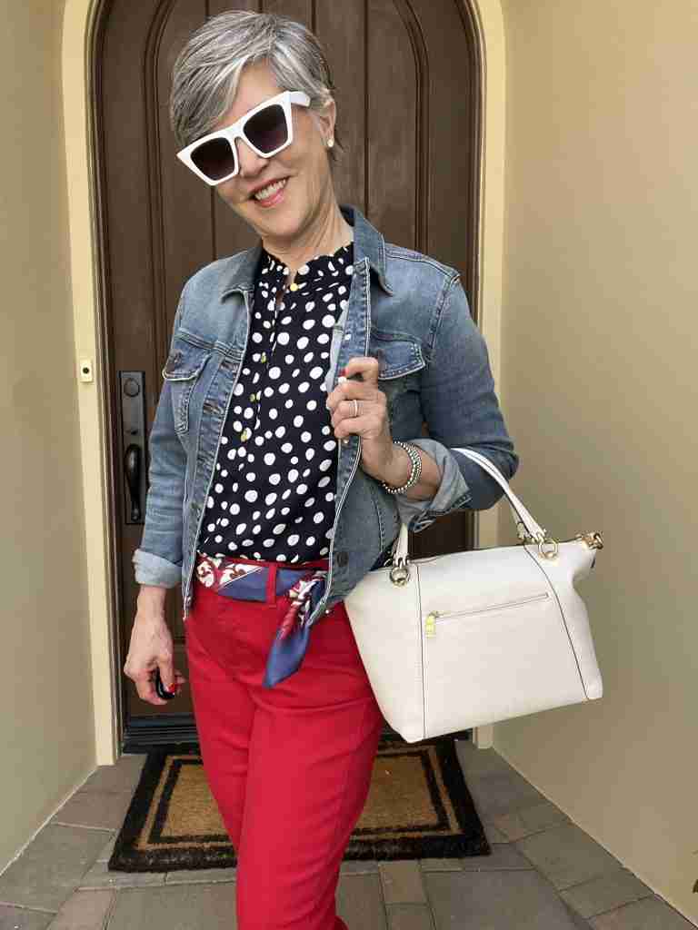 I love this first outfit!  I paired a really dark navy polka dot sleeveless top with a medium-wash jean jacket and some bright red jeggings.  I am accessorized with "diamond" stud earrings and white cat-eye sunglasses.  