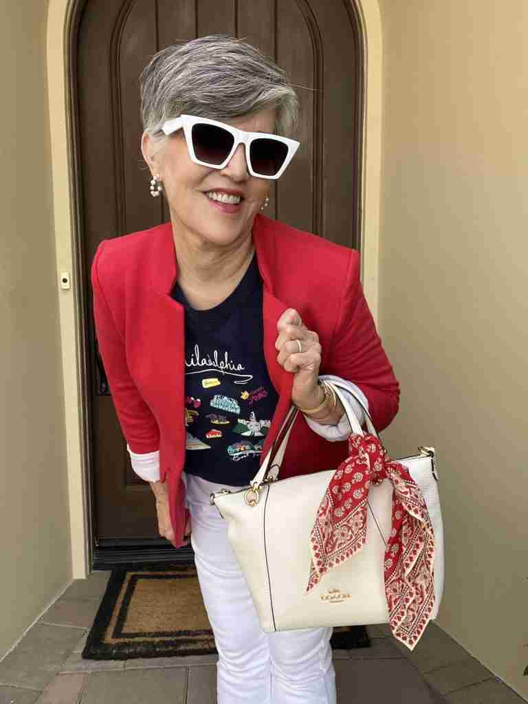 In the second outfit, I took white straight leg jeans and added a fun navy graphic tee.  Philadelphia is where my youngest son and soon-to-be daugter-in-law will be married July 8, 2023.  I added a terrific red knit blazer as well as a white pebbled leather satchel style purse.