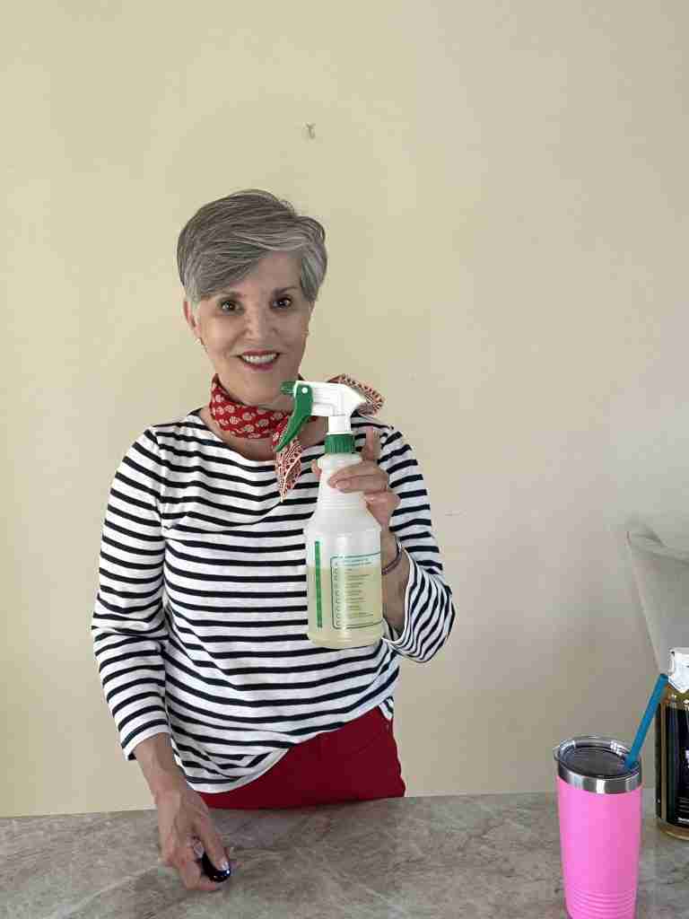 I am wearing a navy striped tee, with a red bandana and pretty zirconium earrings. I am holding a professional spray bottle.