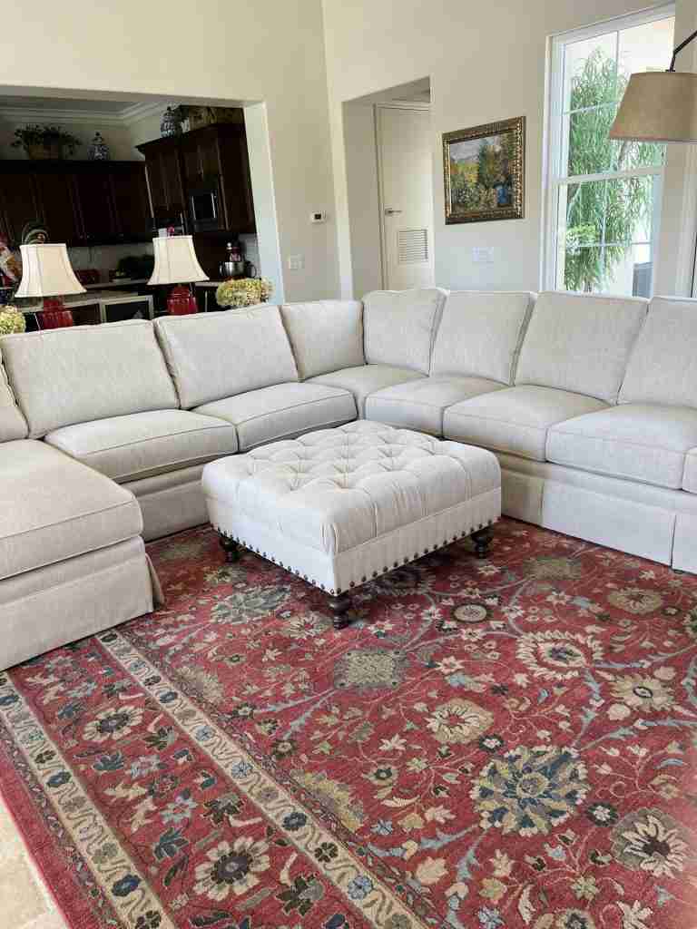 Here is my first of many French Country Living Room Ideas.  Here's my tan linen sectional sofa before accessorizing it.  You can also see the red ginger jar lamps behind the sofa with some silk hydrangeas as well as a faded red, blue, and  cream rug.
