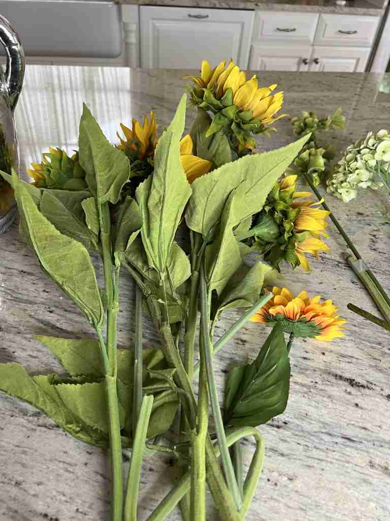 Here are the very realistic-looking faux sunflowers.  Pro-tip: Notice how I fold the branches under rather than cut the stems.  This allows me to use them in the future in different ways.