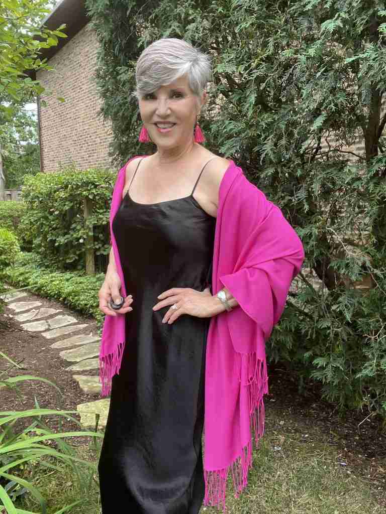 I am wearing a black slip dress with a pink pashmina wrap and pink fringed earrings,  My shoes are nude pumps.