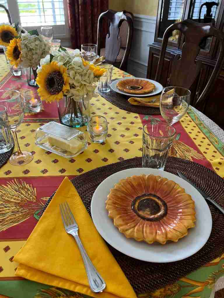 This is the final tablescape with sunflower plates on top of the white ceramic plates.  I have placed water tumblers as well as wine glasses.