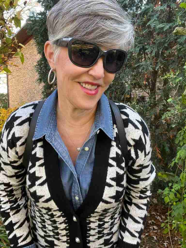 Here I am in the houndstooth cardigan with a denim shirt underneath.  I have a black leather backpack as well as silver pave hoop earrings.  My pants are black faux suede leggings and my boots are black leather riding boots.  Here is a closeup of my face with black sunglasses.