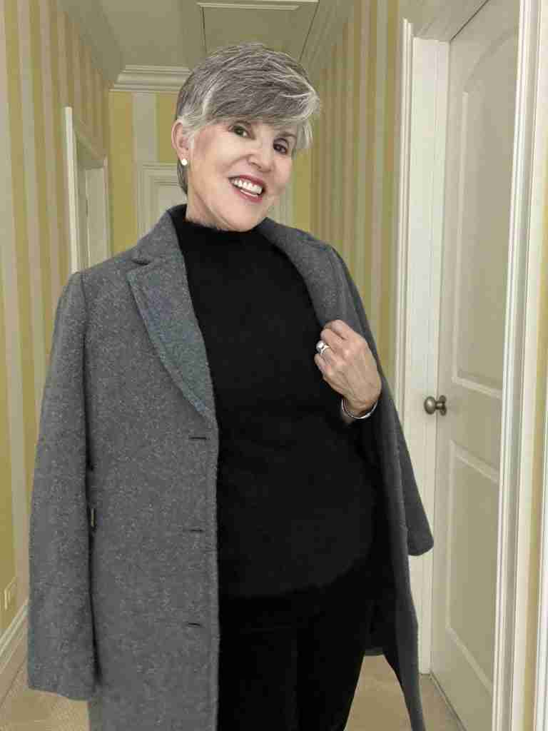 Here is the first of three casual date night outfits.  I am wearing a black fuzzy sleeveless top over black velvet jeans and grey suede booties.  My accessories are faux diamond stud earrings, a stainless-steel watch and bracelet. I added a grey boucle coat draped over my shoulders.