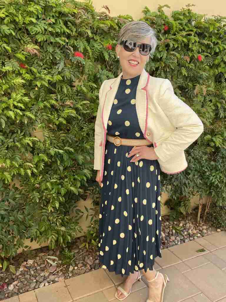 Here is the navy polka dot dress with a cream tweed jacket that has pink fringe trim.  I am wearing dark sunglasses as well as a belt.