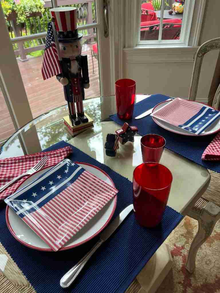 Here is my 4th of July Table decor.  It has a navy placemat, a red striped dinner plate, a flag-inspired dessert plate and an Uncle Sam nutcracker centerpiece.