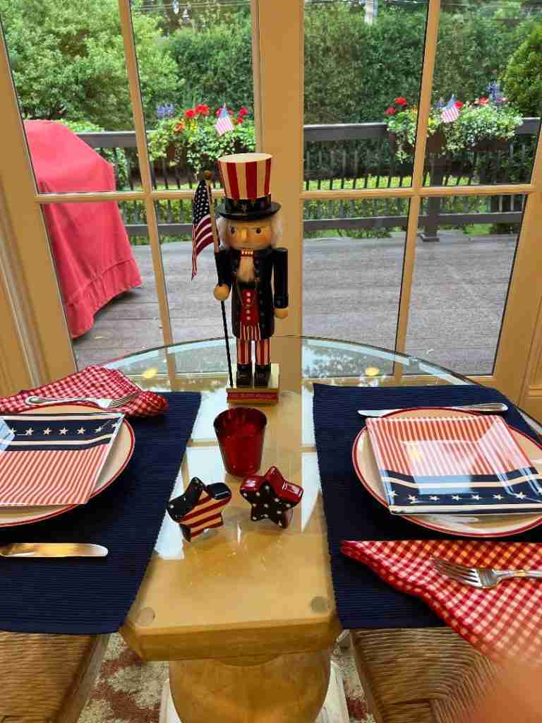 Here's a perfect 4th of July table decor!  There are navy placemats, star-shaped ceramic salt and pepper shaker (so cute!) and even flag-inspired dessert plates.  Lastly, the patriotic centerpiece is an Uncle Sam nutcracker.