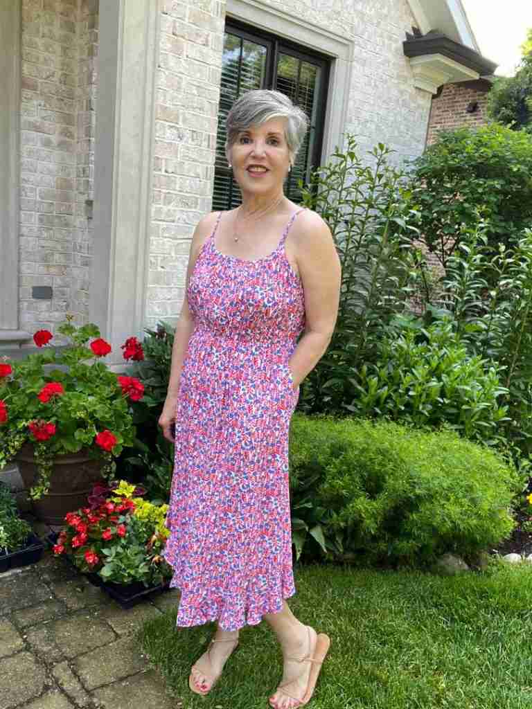 Here is me wearing the red, white, and blue soft floral sleeveless dress with a pair of nude sandals and a pave heart necklace. The dress has pockets.