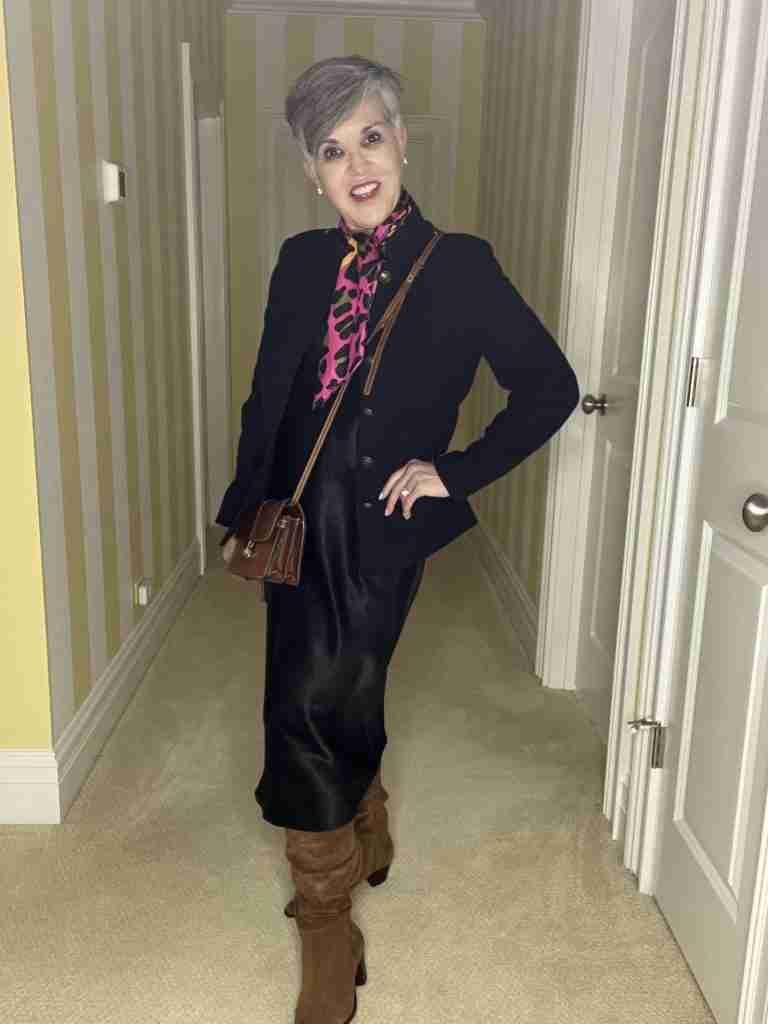 I am wearing the black satin slip dress with a black military jacket, brown scrunched suede boots, a brown cross-body bag and a colorful pink, brown and black leopard scarf.