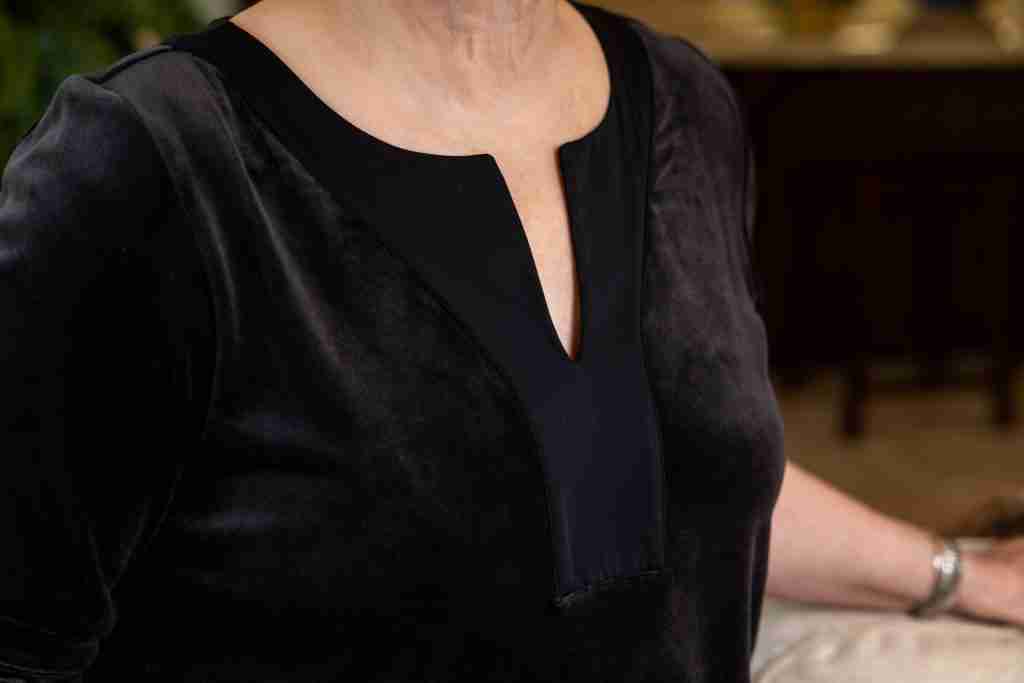 What to wear at home outfit is here.  Black velour tunic with a small v-neckline, velour slim-leg pants and silver loafers.  This photo is a close-up of the satin trimmed black velour tunic.
